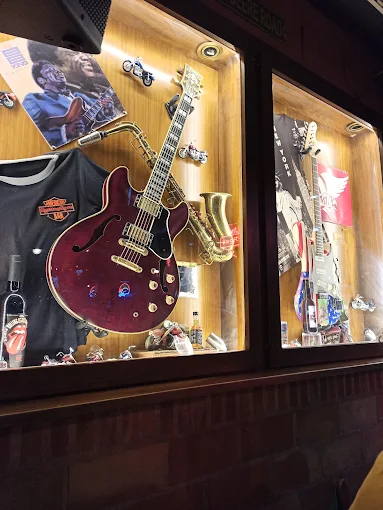 Vitrina del Rolling Rock con una guitarra eléctrica, un saxofón y recuerdos del rock
